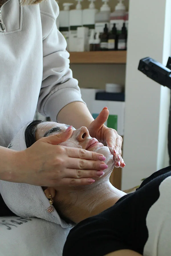 A woman having a luxury facial from a Pretty Perfect by Sophie's team member