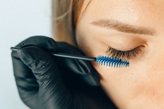 A woman having makeup applied to her eyelashes