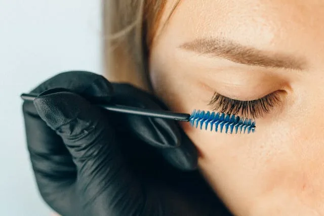 A woman having makeup applied to her eyelashes