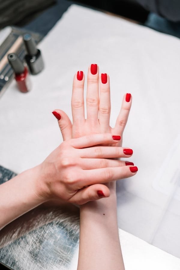 A pair of manicured hands with red nail polish