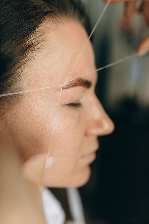 A woman having her eyebrows threaded
